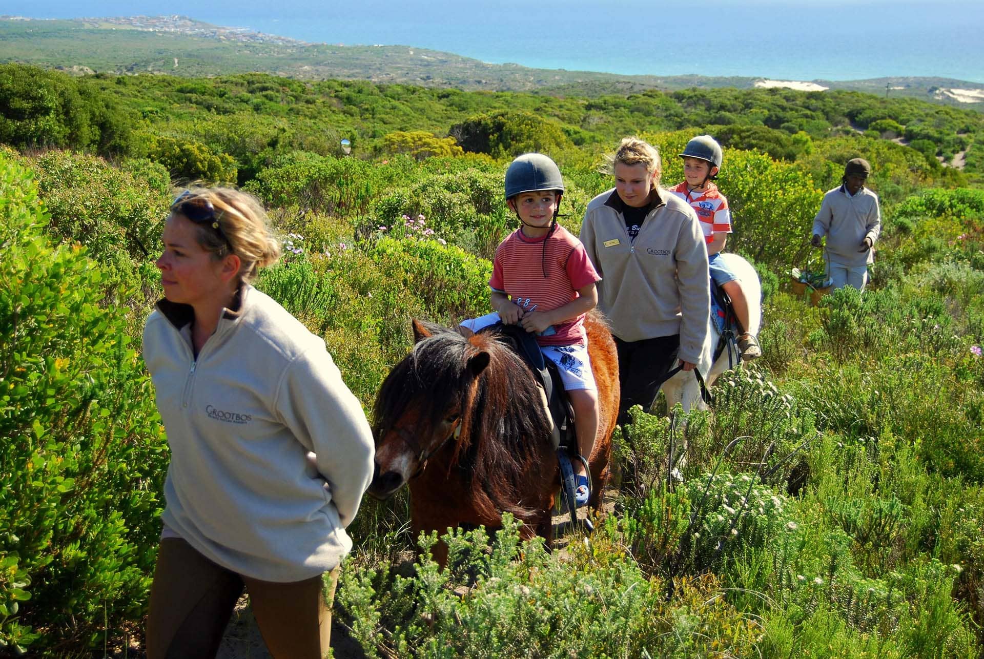 bambini in sella a pony tra i fynbos accompagnati dalle guide
