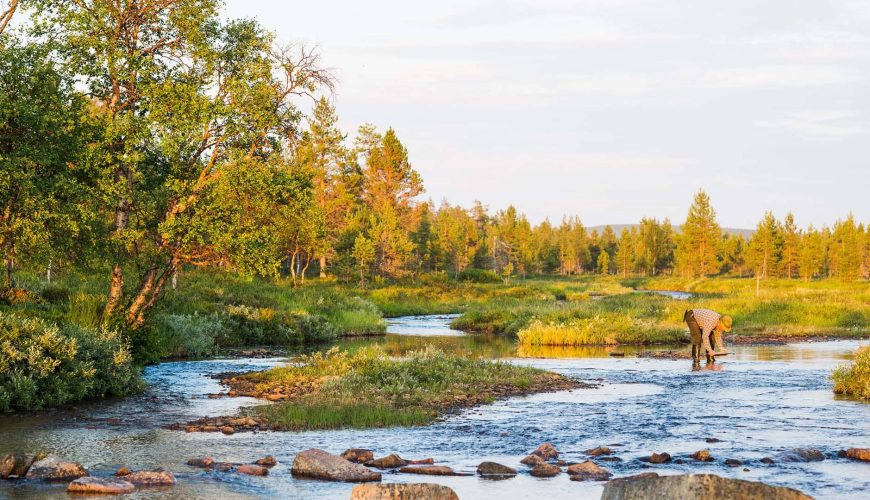 uomo cerca pepite d'oro in un fiume nel lemmenjoki national park
