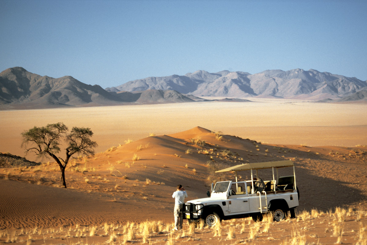 uomo accanto alla jeep ammira il panorama della namibrand reserve
