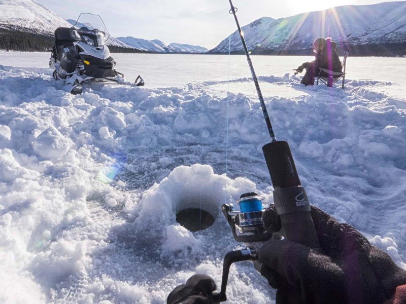 ice fishing vicino alla motoslitta nello yukon
