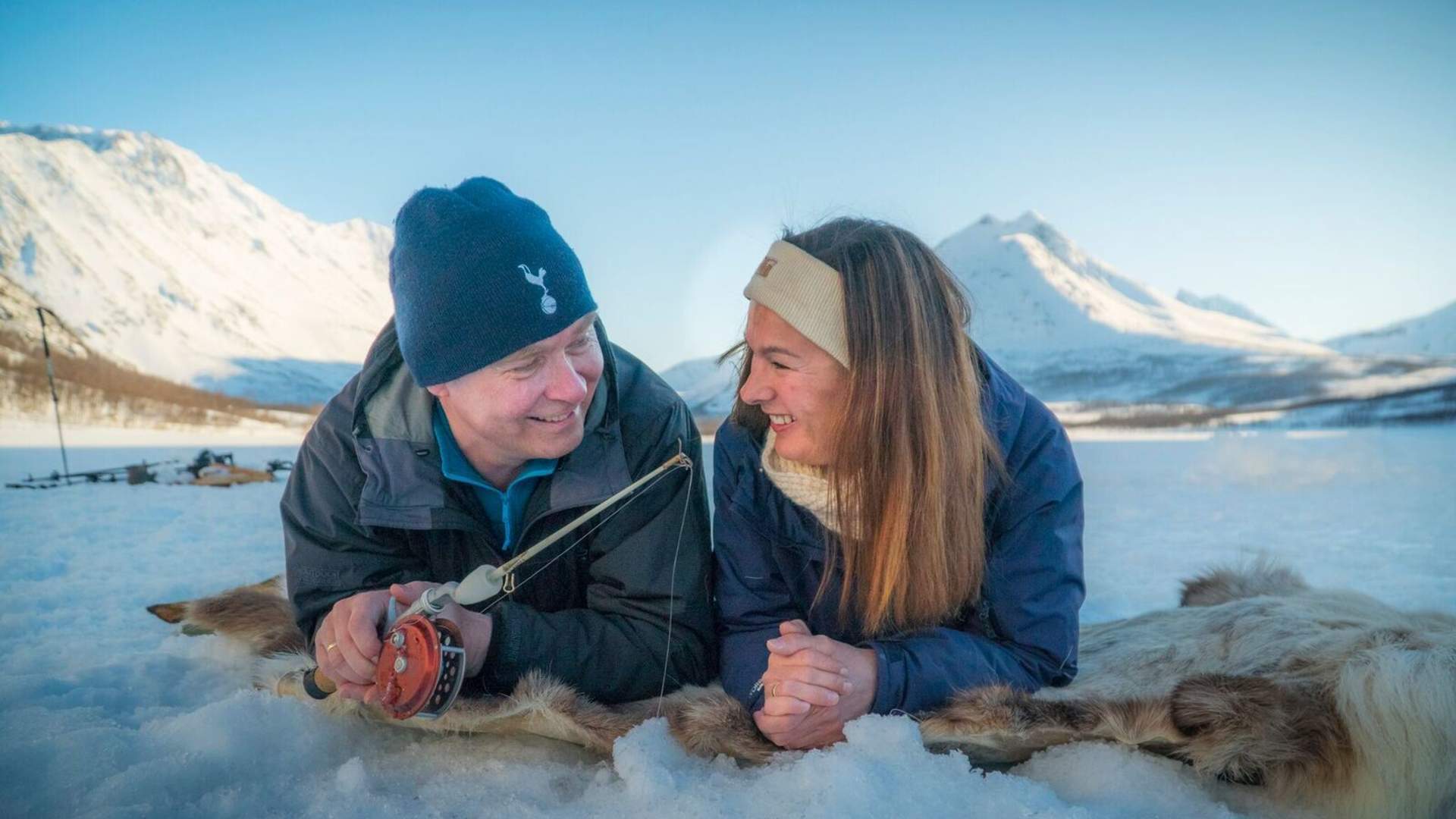 a couple busy ice fishing in Norway